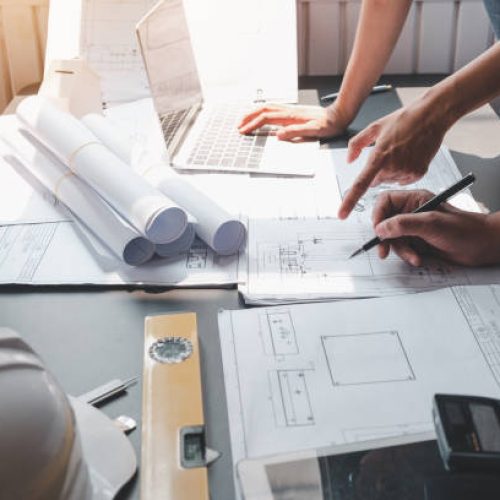 Architect man engineer construction concept using blueprints at the office.